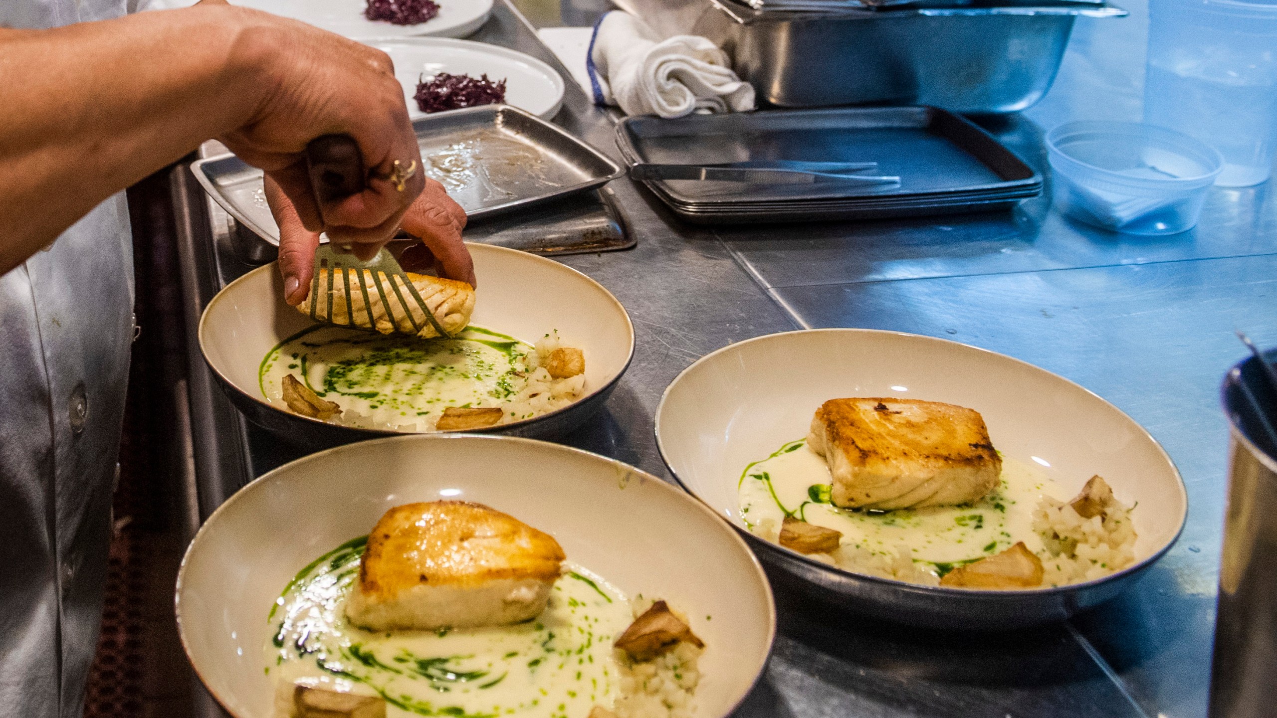 FILE - A worker arranges food onto plates in the kitchen of a restaurant in New York on Dec. 14, 2021. Food workers who showed up while sick or contagious were linked to about 40% of restaurant food poisoning outbreaks with a known cause between 2017 and 2019, federal health officials said Tuesday, May 30, 2023. (AP Photo/Brittainy Newman, File)