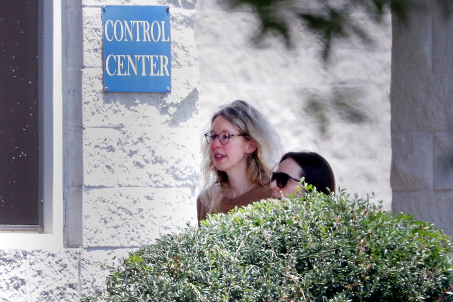 Disgraced Theranos CEO Elizabeth Holmes, left, is escorted by prison officials into a federal women’s prison camp on May 30, 2023, in Bryan, Texas. (Michael Wyke/Associated Press)