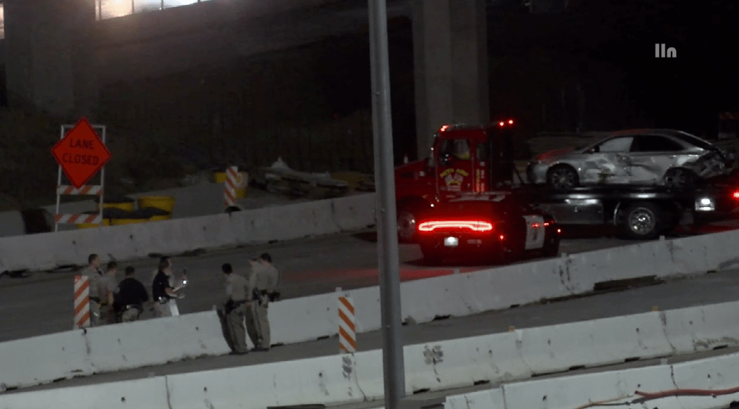 A sedan with major damage is towed from the scene of a road-rage shooting and crash in Corona on April 30, 2023. (LOUDLABS)