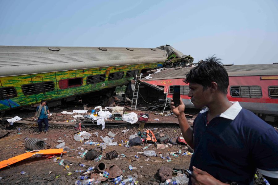 People inspect the site of passenger trains that derailed in Balasore district, in the eastern Indian state of Orissa, Saturday, June 3, 2023. Rescuers are wading through piles of debris and wreckage to pull out bodies and free people after two passenger trains derailed in India, killing more than 280 people and injuring hundreds as rail cars were flipped over and mangled in one of the country’s deadliest train crashes in decades. (AP Photo/Rafiq Maqbool)