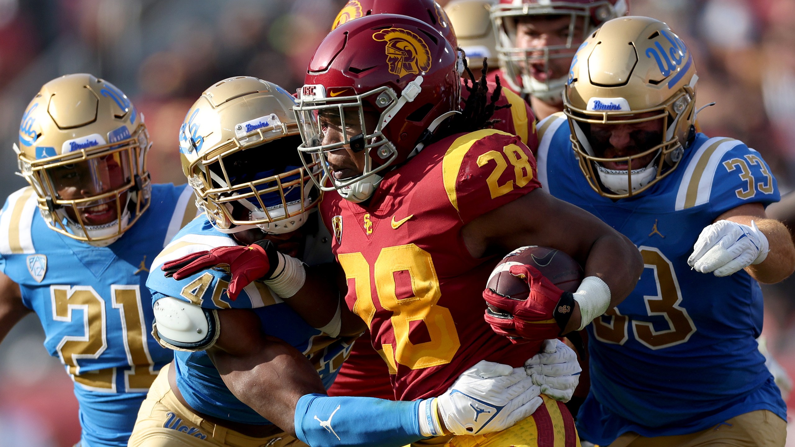 Keaontay Ingram of the USC Trojans rushes the ball as he is met by Mitchell Agude of the UCLA Bruins during the first quarter at Los Angeles Memorial Coliseum on Nov. 20, 2021 in Los Angeles. (Harry How/Getty Images)