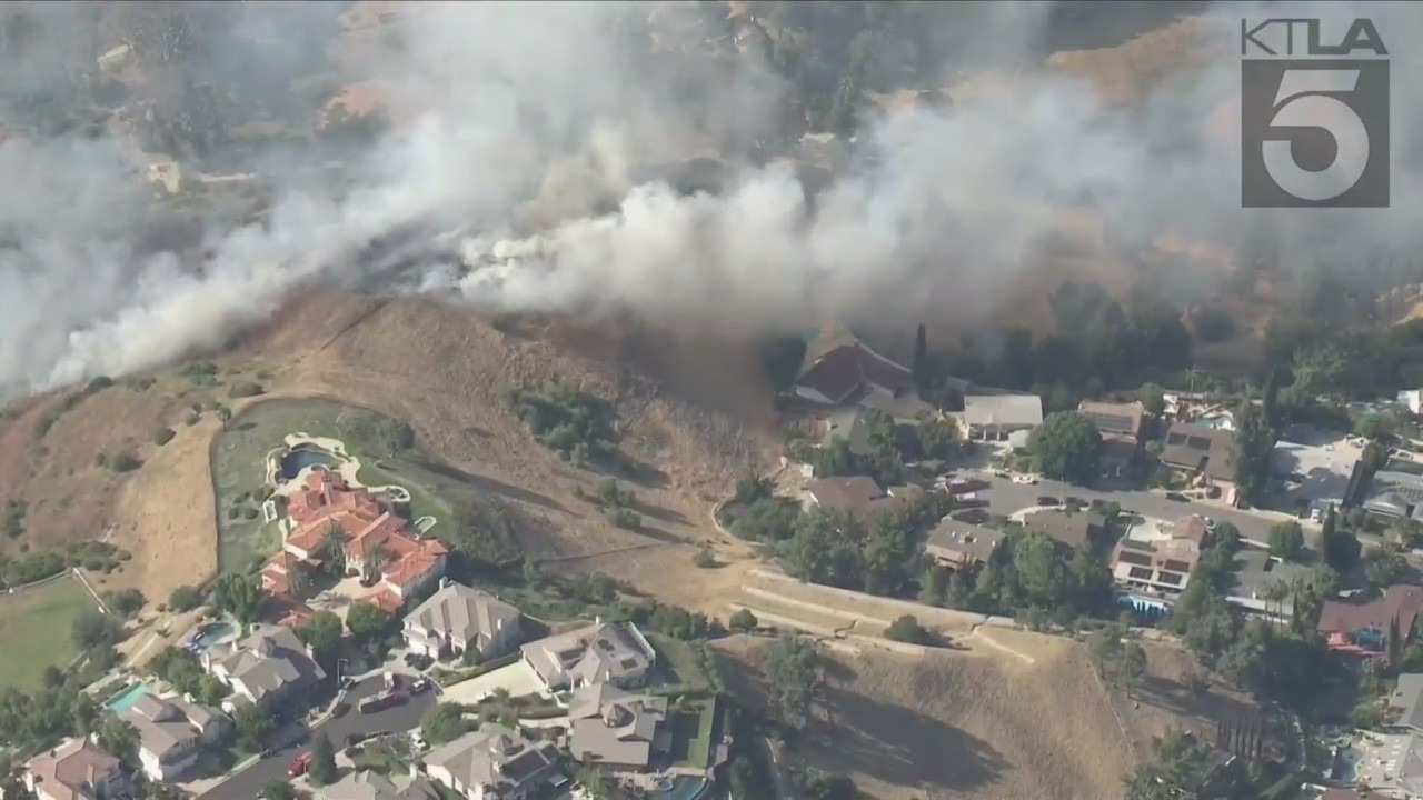 West Hills brush fire threatens a neighborhood