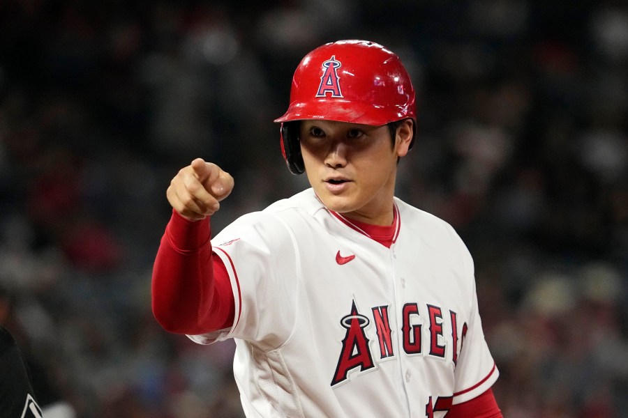 Los Angeles Angels' Shohei Ohtani talks to members of the Chicago White Sox as they sit in their dugout after hitting a single during the eighth inning of a baseball game Wednesday, June 28, 2023, in Anaheim, Calif. (AP Photo/Mark J. Terrill)