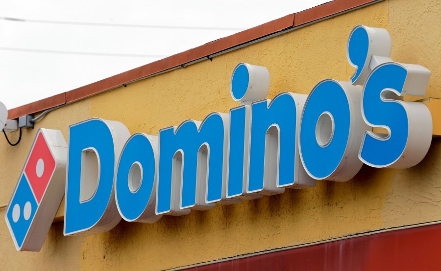 FILE- A Domino's Pizza sign hangs above a location in Hialeah, Fla., Oct. 27, 2016. Domino’s Pizza said Wednesday, July 12, 2023, it is partnering with Uber Eats to make deliveries in the U.S. and 27 international markets. (AP Photo/Alan Diaz, File)