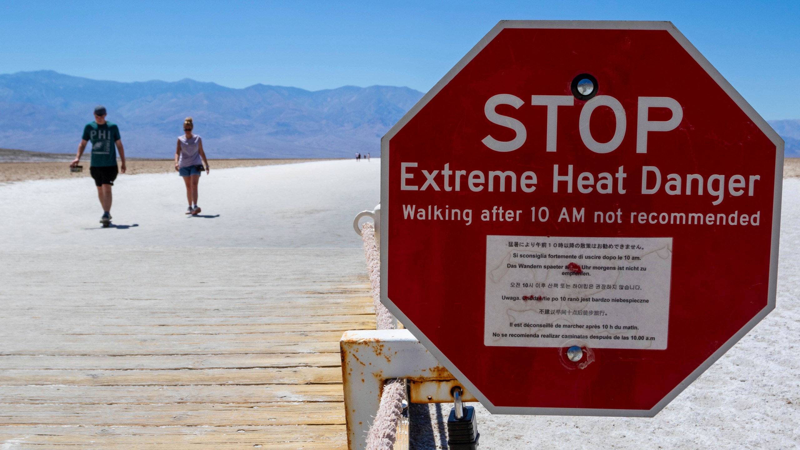 A sign warns people of extreme heat in multiple languages on Tuesday, July 11, 2023, in Death Valley National Park, Calif. July is the hottest month at the park with an average high of 116 degrees (46.5 Celsius). (AP Photo/Ty ONeil)