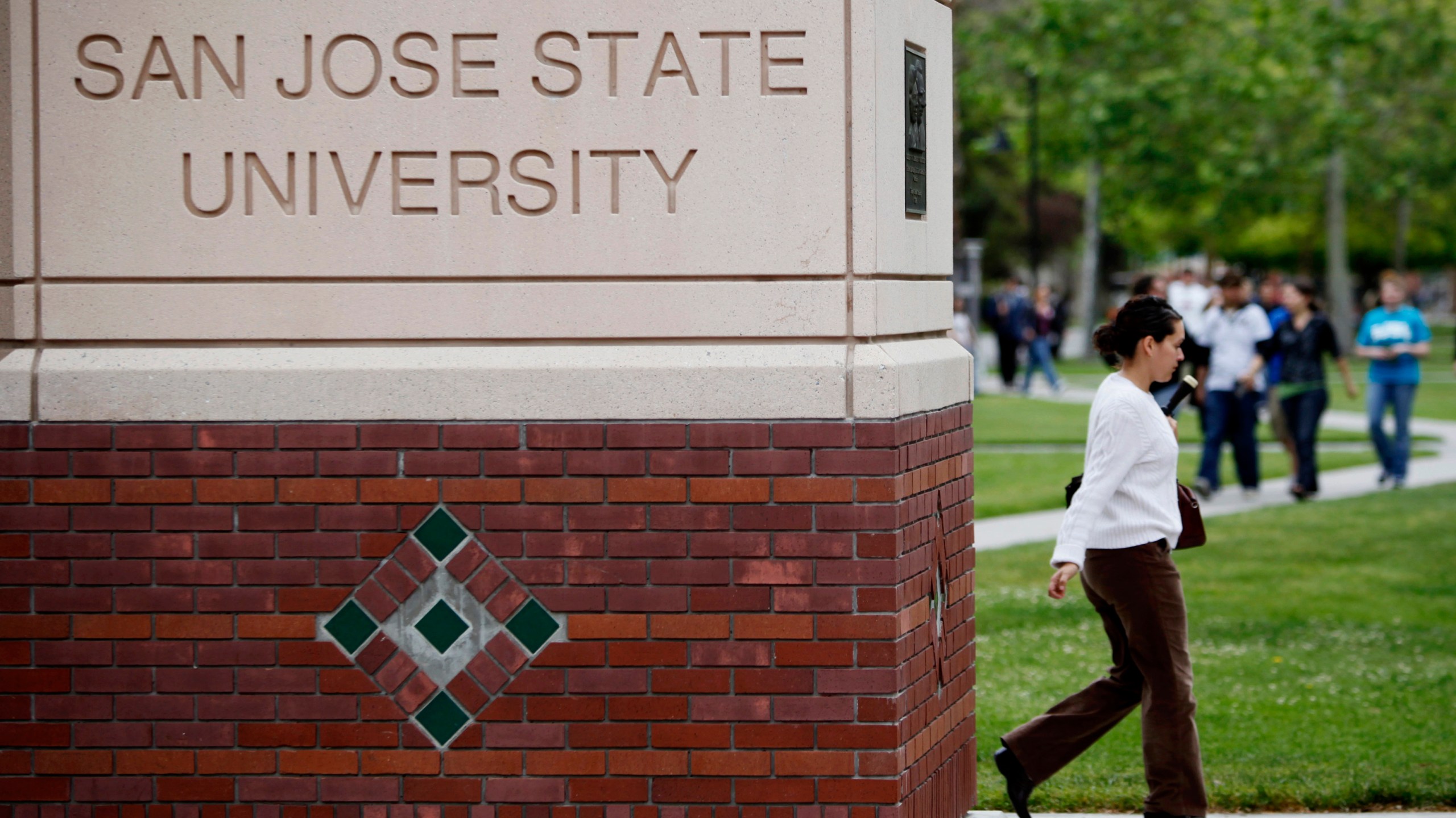 CORRECTS TO SEVEN YEARS INSTEAD OF SIX - FILE - People walk on the campus of San Jose State University in San Jose, Calif., on May 5, 2009. A flawed policy at California State University, the largest higher education system in the country, contributed to the closure of nearly a dozen sexual harassment cases without thorough explanation, a state audit reviewing dozens of cases over the span of seven years found. The state auditor investigated allegations reported by employees at the California State University chancellor's office, California State University, Fresno, San Jose State University and Sonoma State University. (AP Photo/Paul Sakuma, File)