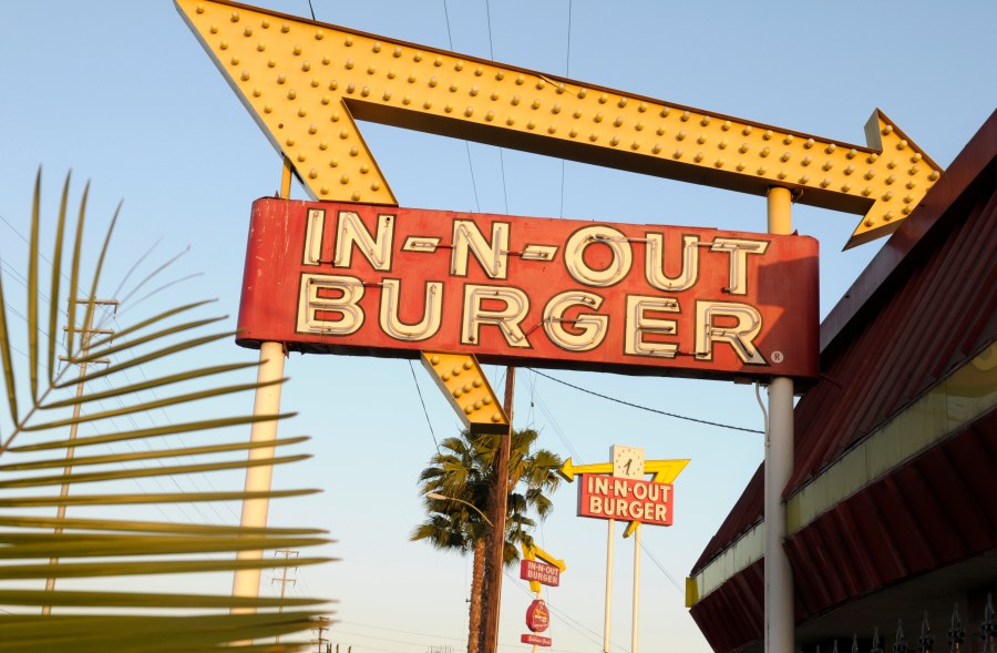 FILE - In-N-Out Burger signs fill the skyline on Tuesday, June 8, 2010, in Calif. In-N-Out is barring employees in five states from wearing masks unless they have a doctor’s note, according to internal company emails leaked on social media last week. (AP Photo/Adam Lau, File)