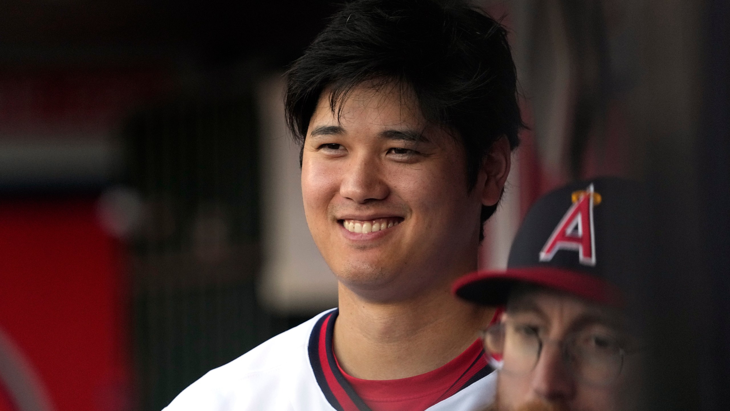 Los Angeles Angels' Shohei Ohtani smiles as he stands in the dugout prior to a baseball game against the Pittsburgh Pirates Saturday, July 22, 2023, in Anaheim, Calif. (AP Photo/Mark J. Terrill)