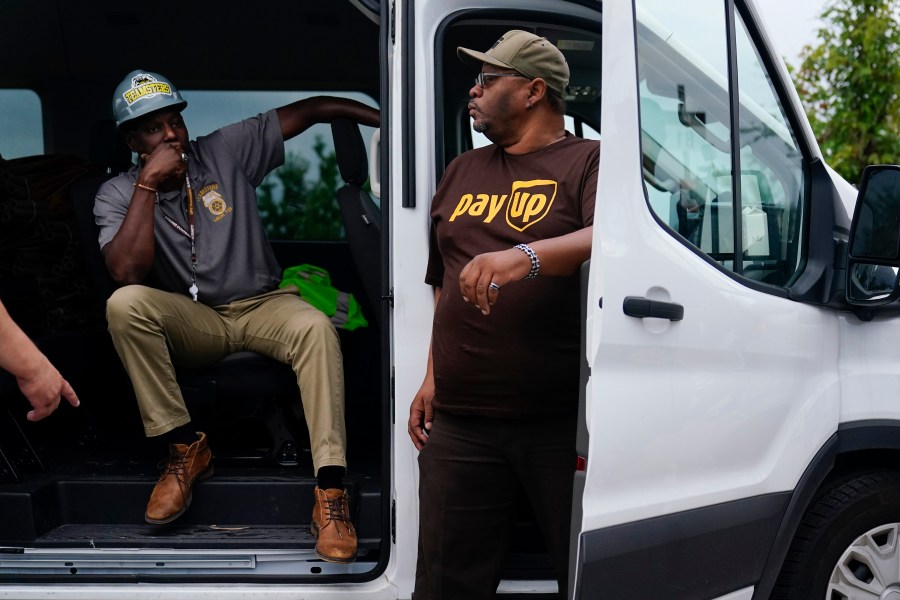 FILE - UPS teamsters and workers wait before a rally, Friday, July 21, 2023, in Atlanta, as a national strike deadline nears. UPS has reached a contract agreement with its 340,000-person strong union Tuesday, July 25, averting a strike that had the potential to disrupt logistics nationwide for businesses and households alike. (AP Photo/Brynn Anderson, File)