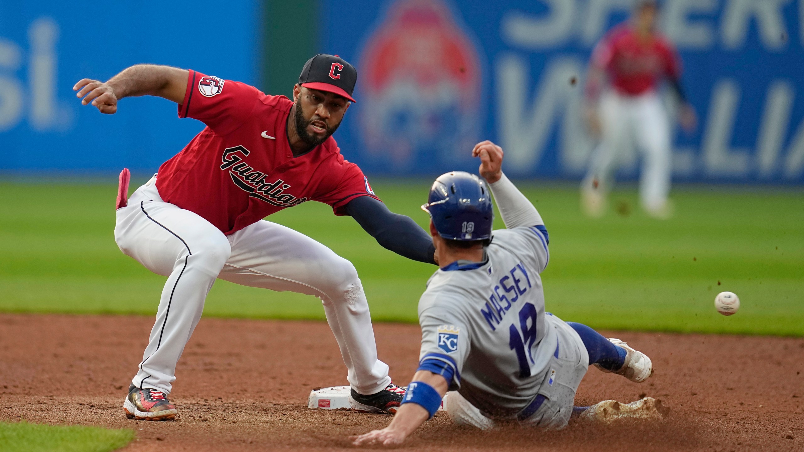 Kansas City Royals' Michael Massey, right, steals second base as the throw gets past Cleveland Guardians shortstop Amed Rosario, left, on a throwing error by catcher Bo Naylor during the fifth inning of a baseball game Tuesday, July 25, 2023, in Cleveland. Massey advanced to third. (AP Photo/Sue Ogrocki)