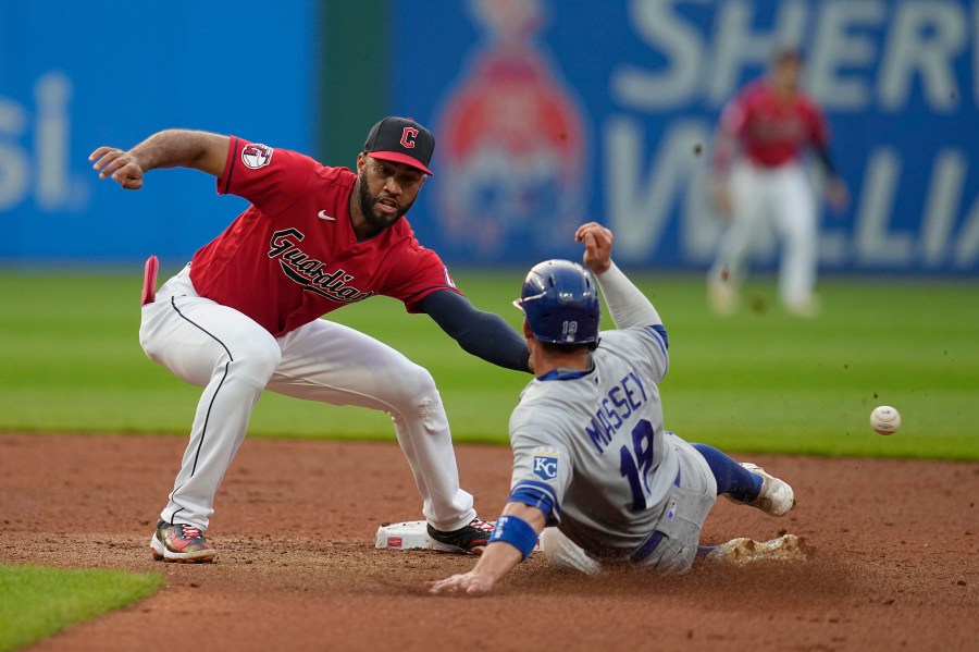 Kansas City Royals' Michael Massey, right, steals second base as the throw gets past Cleveland Guardians shortstop Amed Rosario, left, on a throwing error by catcher Bo Naylor during the fifth inning of a baseball game Tuesday, July 25, 2023, in Cleveland. Massey advanced to third. (AP Photo/Sue Ogrocki)