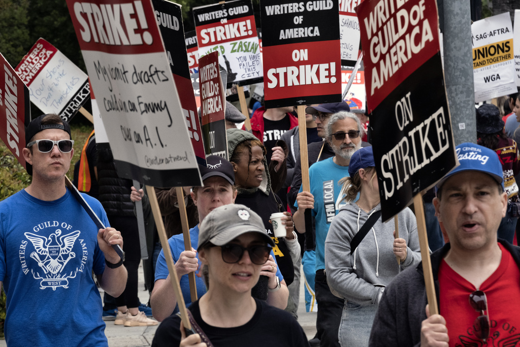 Picketers pass near a studio entrance during a Writers Guild rally.