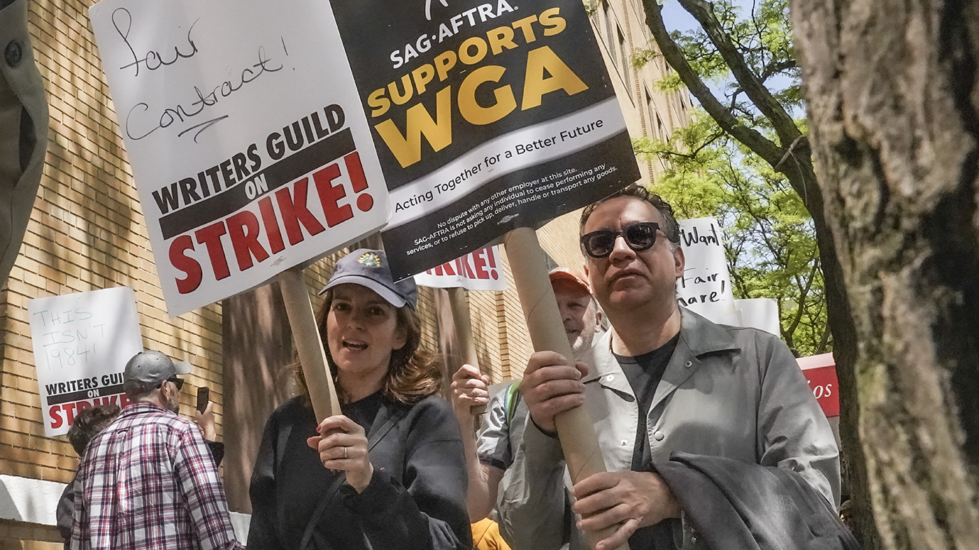 Actors and comedians Tina Fey, center, and Fred Armisen, right, join striking members of the Writers Guild of America on the picket line during a rally outside Silvercup Studios in New York on May 9, 2023. (Bebeto Matthews/Associated Press)