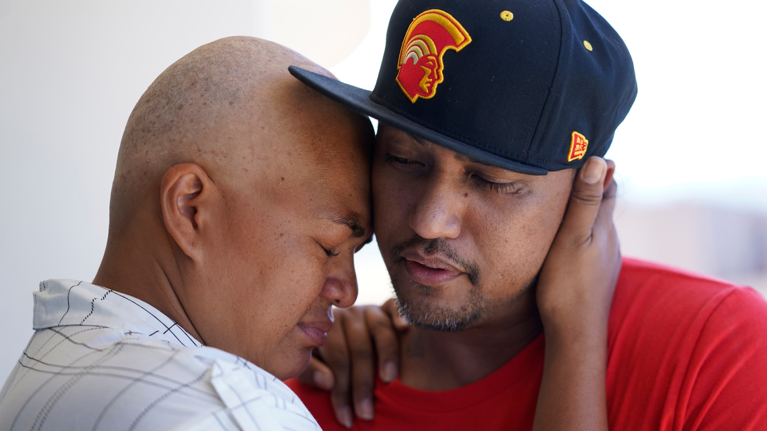 JP Mayoga, right, a chef at the Westin Maui, Kaanapali, and his wife, Makalea Ahhee, hug on their balcony at the hotel and resort, Sunday, Aug. 13, 2023, near Lahaina, Hawaii. About 200 employees are living there with their families. Officials urge tourists to avoid traveling to Maui as many hotels prepare to house evacuees and first responders on the island where a wildfire demolished a historic town and killed dozens of people. (AP Photo/Rick Bowmer)