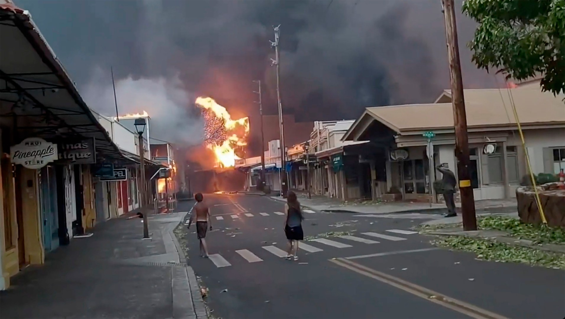 People watch as smoke and flames fill the air from raging wildfires