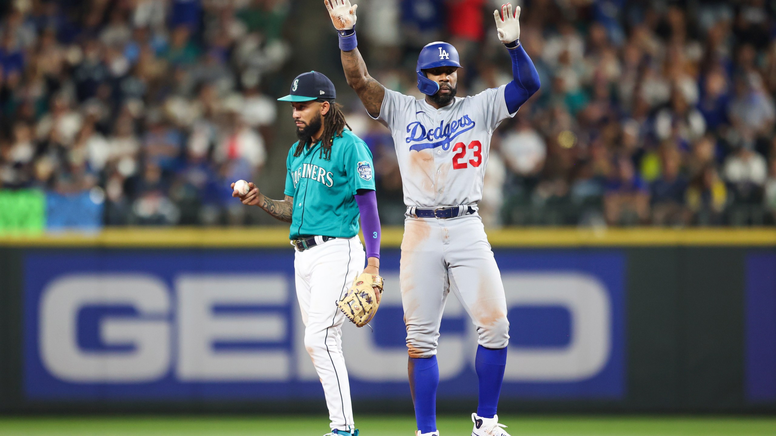 Los Angeles Dodgers' Jason Heyward celebrates after hitting a double as Seattle Mariners shortstop J.P. Crawford reacts during the seventh inning of a baseball game Saturday, Sept. 16, 2023, in Seattle. (AP Photo/Maddy Grassy)