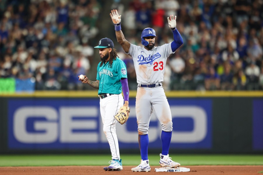 Los Angeles Dodgers' Jason Heyward celebrates after hitting a double as Seattle Mariners shortstop J.P. Crawford reacts during the seventh inning of a baseball game Saturday, Sept. 16, 2023, in Seattle. (AP Photo/Maddy Grassy)