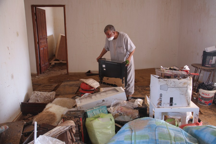 Derna flood survivor Abdul Salam Anwisi cleans his home after flooding caused by Mediterranean storm Daniel, in Derna, Libya, Sunday, Sept. 17, 2023. Anwisi said he woke up at one-thirty in the morning to a scream from outside, to find his neighbours' homes flooded with water. He, his sons, and other neighbours rushed to rescue the stranded families by pulling them from the roof of their house. Thousands of Libyans have lost family members, friends and neighbors in the devastating floods that engulfed the country's east. (AP Photo/Yousef Murad)