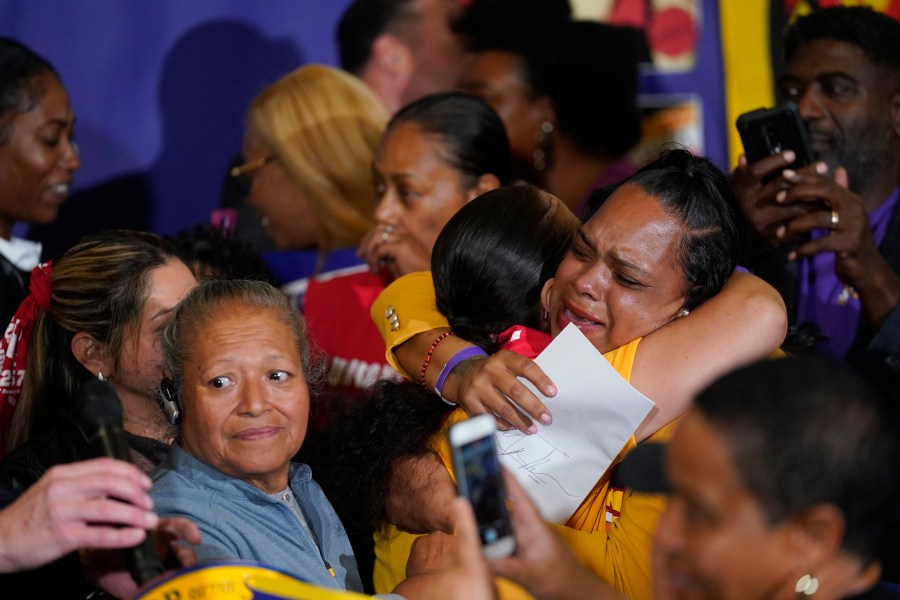 Anneisha Williams, right, who works at a Jack in the Box restaurant in Southern California celebrates as she holds the bill signed by California Gov. Gavin Newsom at the SEIU Local 721 in Los Angeles, Thursday, Sept. 28, 2023. California fast food workers will be paid at least $20 per hour next year under the new law signed by Newsom. (AP Photo/Damian Dovarganes)