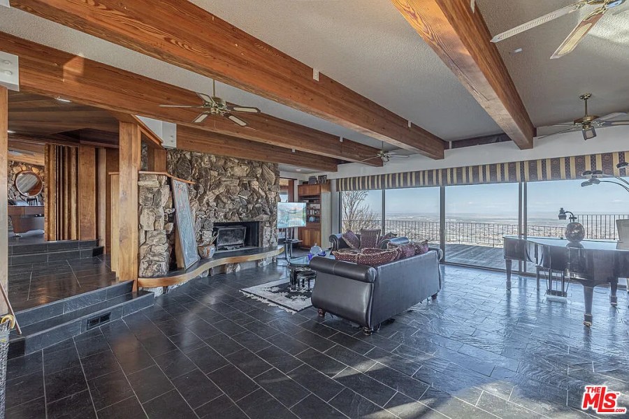 The home features stone tile flooring and stone fireplace in addition to unmatched views of the Antelope Valley. (AVOH)