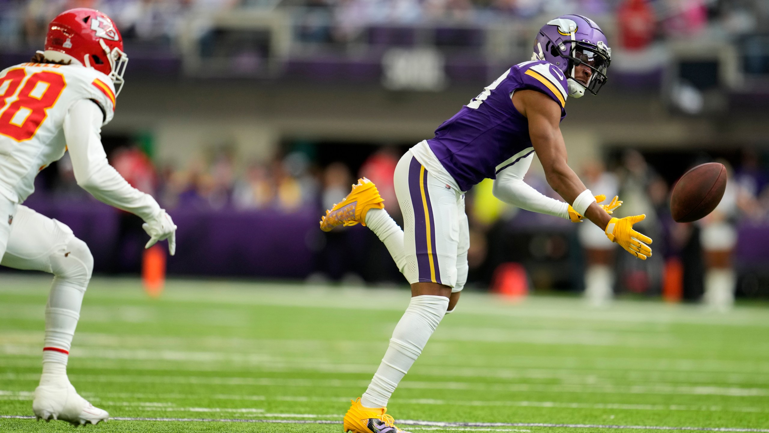 Minnesota Vikings wide receiver Justin Jefferson looks to catch a pass in front of Kansas City Chiefs cornerback L'Jarius Sneed, left, during the first half of an NFL football game, Sunday, Oct. 8, 2023, in Minneapolis. The pass was incomplete. (AP Photo/Abbie Parr)