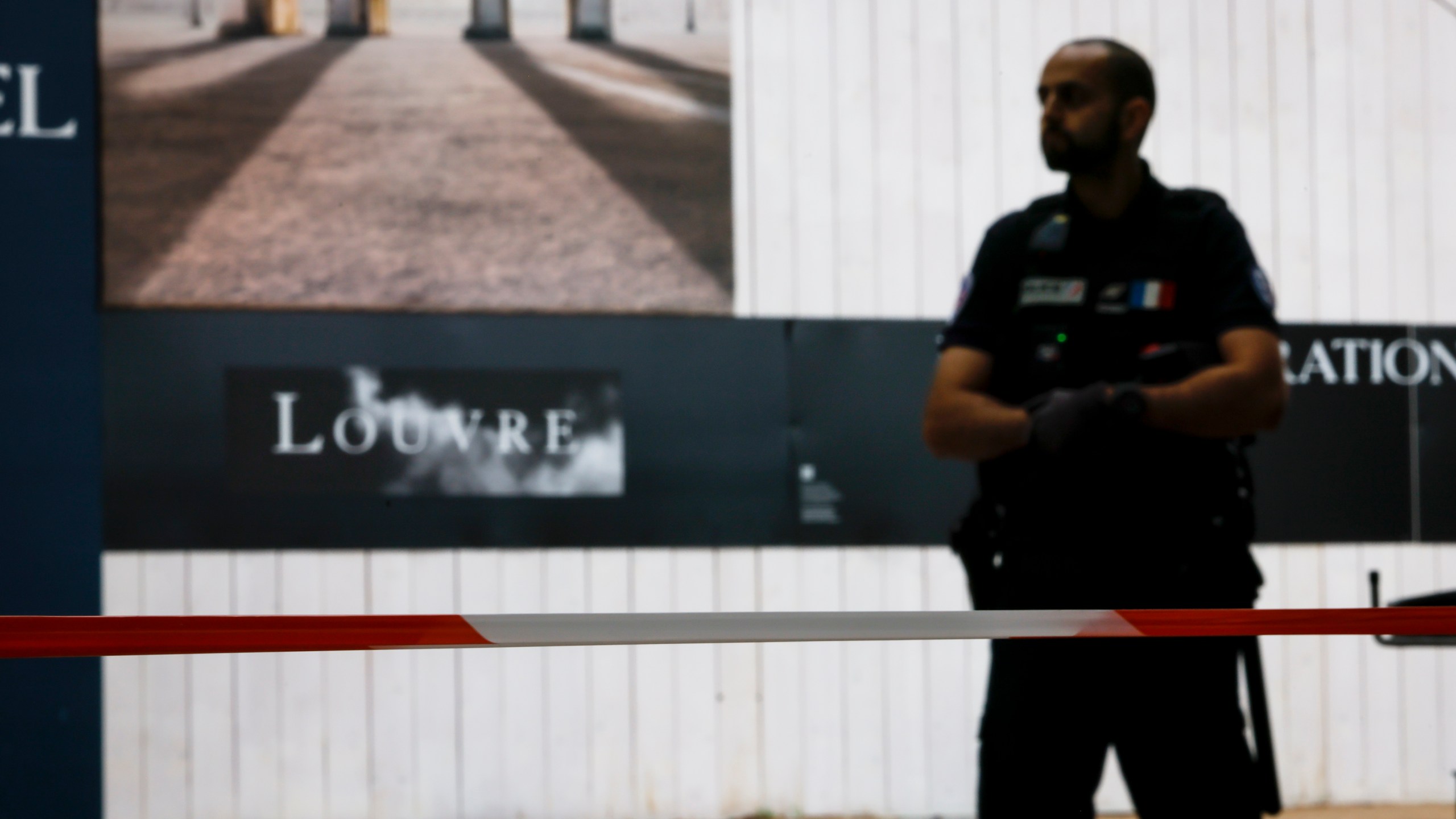 A police officer stands guard outside the Louvre Museum as people are evacuated after it received a written threat, in Paris, Saturday Oct. 14, 2023. The Louvre Museum says it is closing for the day and evacuating all visitors and staff after a threat. (AP Photo/Thomas Padilla)