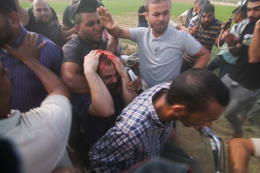 FILE - Palestinians transport a captured Israeli civilian, center, from Kibbutz Kfar Azza into the Gaza Strip on Saturday, Oct. 7, 2023. Israel's military brought together a group of foreign correspondents Monday, Oct. 16, to screen a 40-minute reel of gruesome footage compiled from the Hamas attack last week. The screening came as Israel's military faces increasing pressure to back up their claims of atrocities committed by the militants. (AP Photo/Hatem Ali, File)