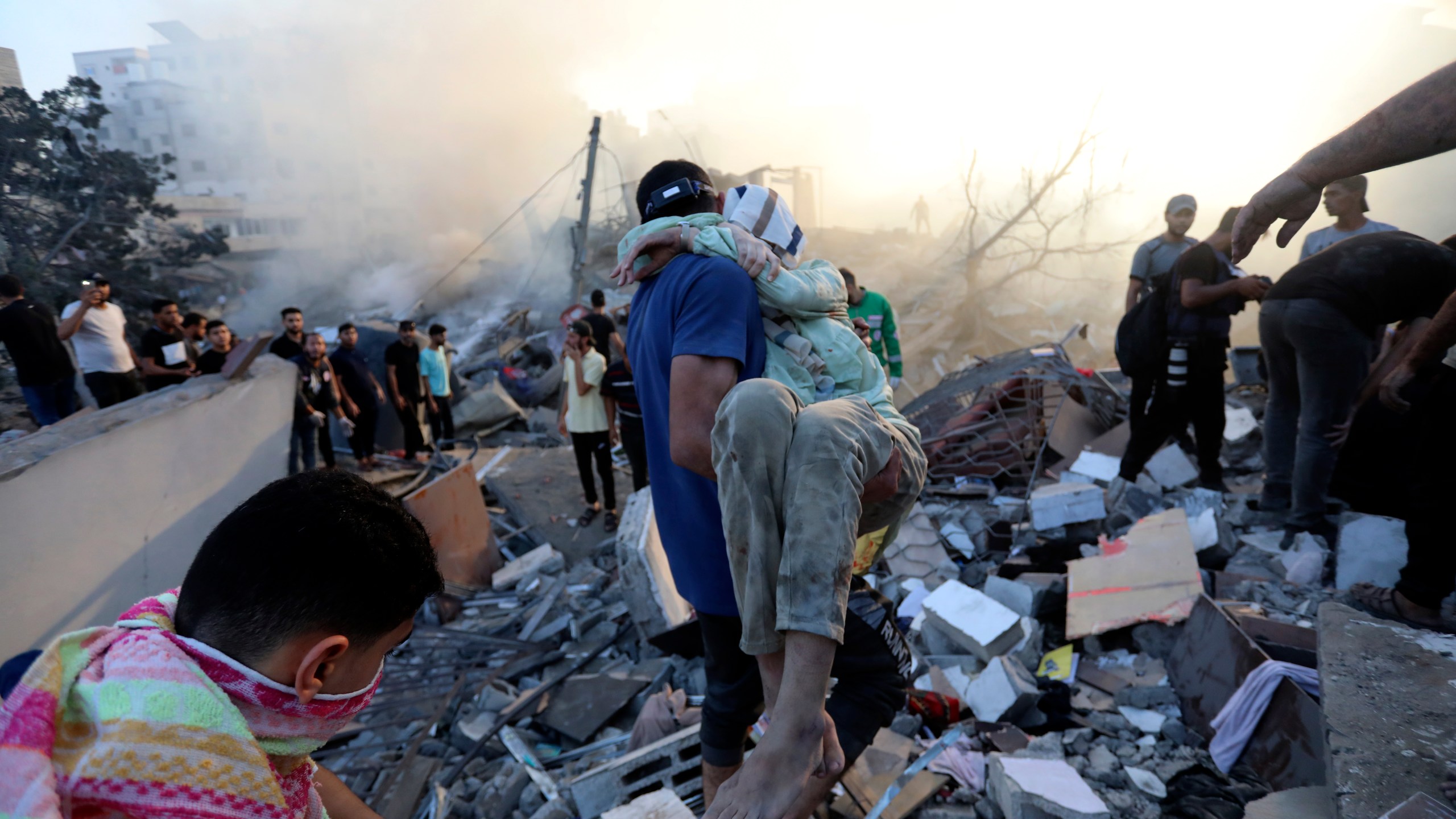 A Palestinian man evacuates a wounded girl out of the destruction following Israeli airstrikes on Gaza City, Wednesday, Oct. 25, 2023. The U.N. warned on Wednesday that it is on the verge of running out of fuel in the Gaza Strip, forcing it to sharply curtail relief efforts in the territory blockaded and devastated by Israeli airstrikes since Hamas militants launched an attack on Israel more than two weeks ago. (AP Photo/Abed Khaled)