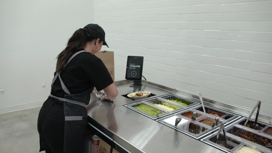 Once completed, the  chipotle bowl or salad raises up from its assembly system to an employee who is working on additional items. (Promotional image from Chipotle)