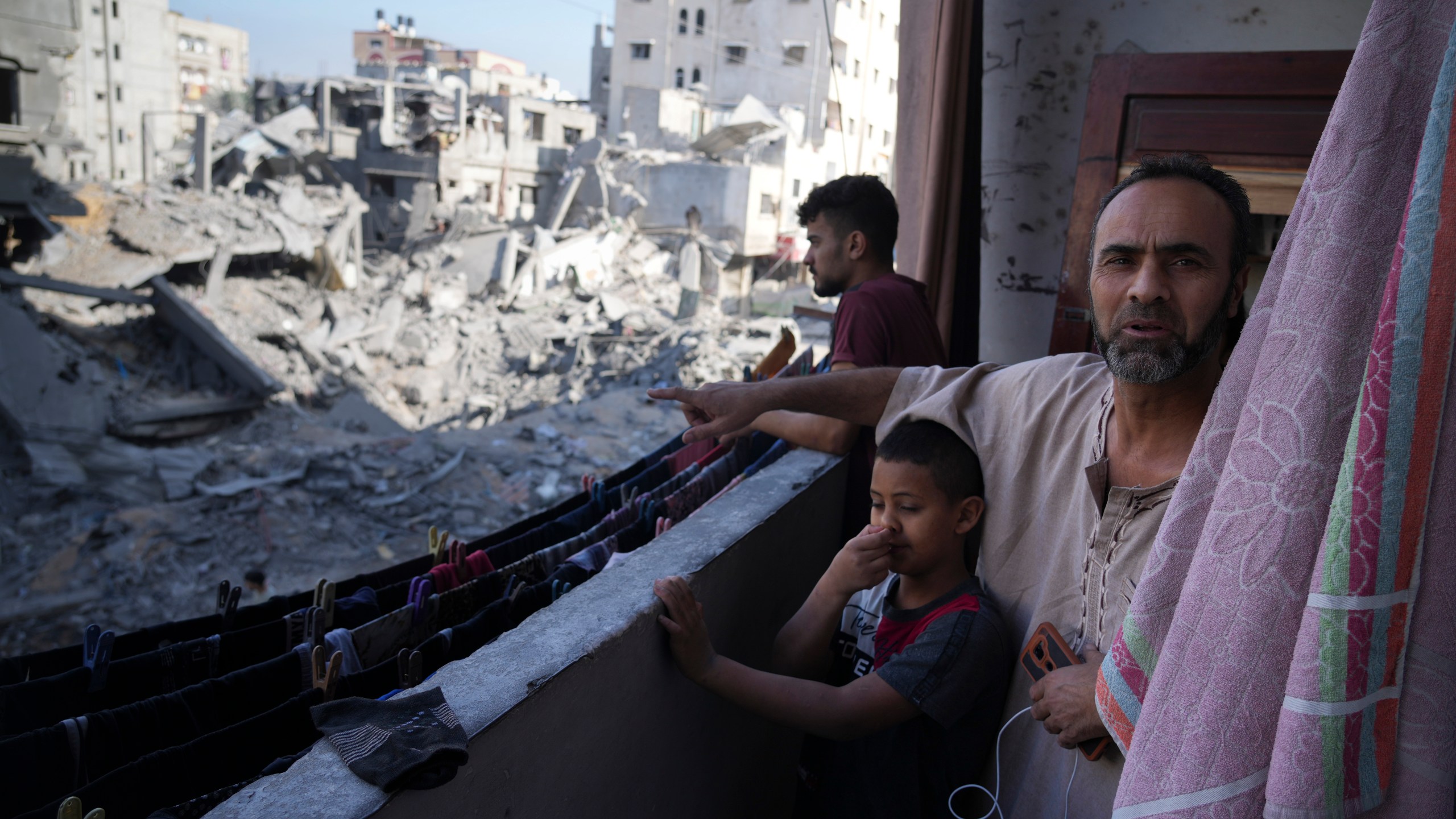 Palestinian points at destruction by the Israeli bombardment of the Gaza Strip in the Maghazi refugee camp, Friday, Nov. 3, 2023. (AP Photo/Hatem Moussa)