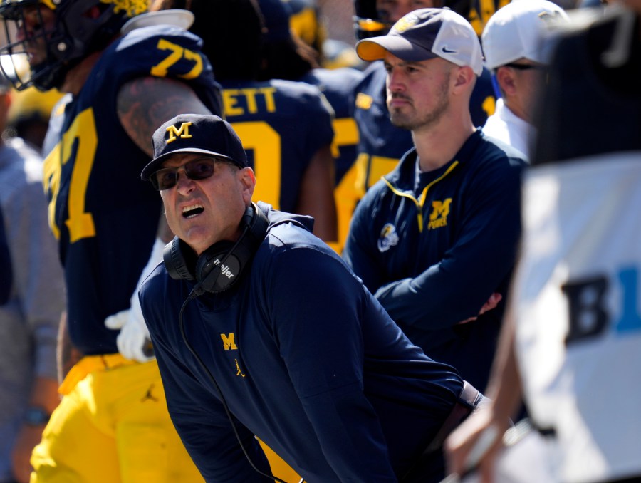 FILE - Michigan head coach Jim Harbaugh, front left, watches against Rutgers as analytics assistant Connor Stalions, right, looks on during an NCAA college football game in Ann Arbor, Mich., Sept. 23, 2023. A Michigan judge who champions peacemaking principles in court will preside over a hearing on Friday that will determine whether Jim Harbaugh can coach and close the regular season on the field with the third-ranked Wolverines. Attorneys for Harbaugh and the university are asking Judge Timothy P. Connors to at least temporarily lift the Big Ten’s penalty against him for a sign-stealing scheme. (AP Photo/Paul Sancya, FILE)