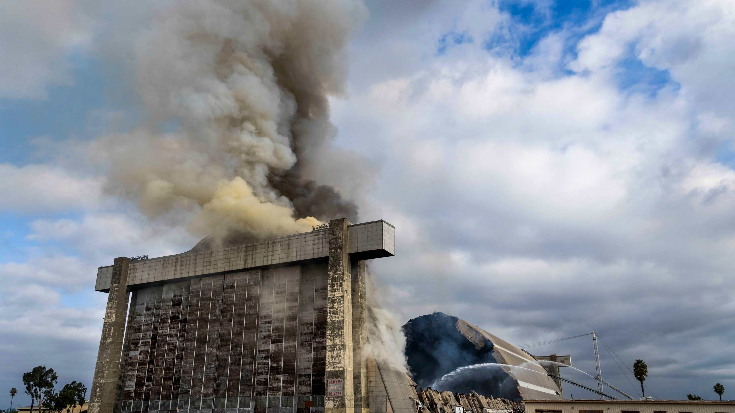 Orange County firefighters battle a fire affecting the north hangar at the Tustin Air Base in Tustin, Calif. Tuesday, Nov. 7, 2023. (Paul Bersebach/The Orange County Register via AP)