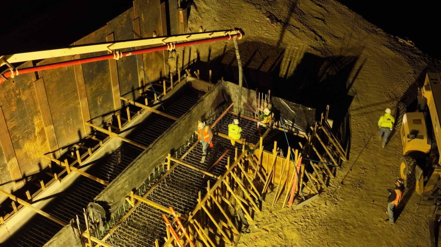 An aerial photo taken at night showing where crews are placing hundreds of tons of wet concrete for the foundation of the abutment, or bridge wall, next to the southbound lanes of US Highway 101 near Liberty Canyon Road in Agoura Hills, California, to build the Wallis Annenberg Wildlife Crossing. (Caltrans)