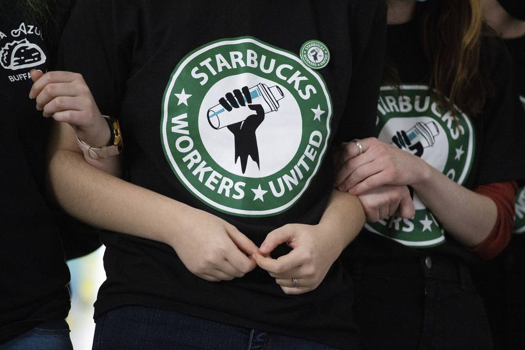 Starbucks employees and supporters link arms during a union election watch party Dec. 9, 2021, in Buffalo, N.Y.