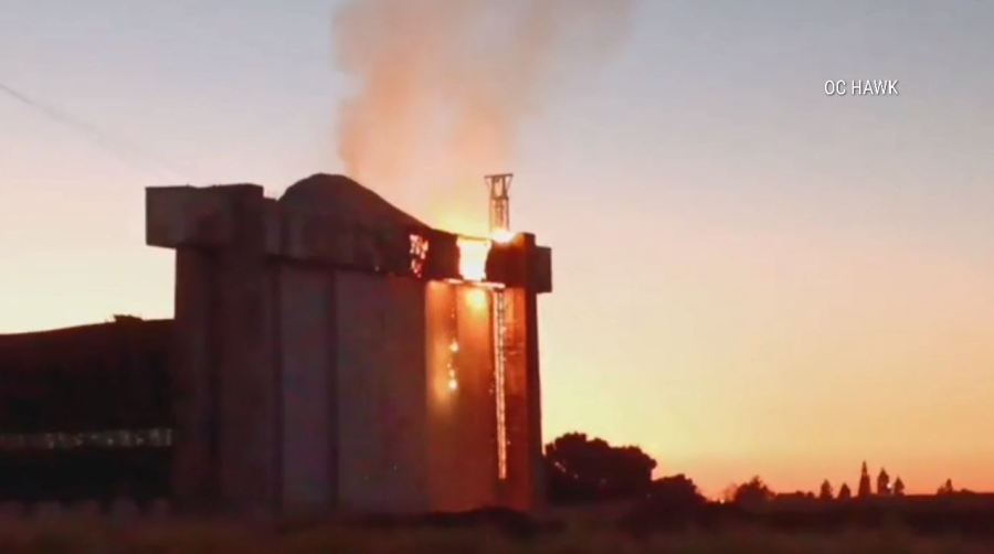 An active flare-up of a fire seen on the doors of a historic airbase hangar in Tustin on Nov. 11 has prompted concerns from residents. (OC Hawk)