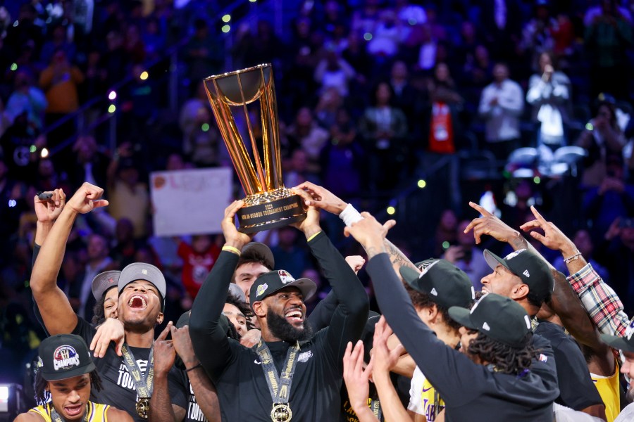 Los Angeles Lakers forward LeBron James, center, lifts the the NBA Cup while celebrating with teammates after they defeated the Indiana Pacers 123-109 in the championship game in the NBA basketball In-Season Tournament on Saturday, Dec. 9, 2023, in Las Vegas.(AP Photo/Ian Maule)