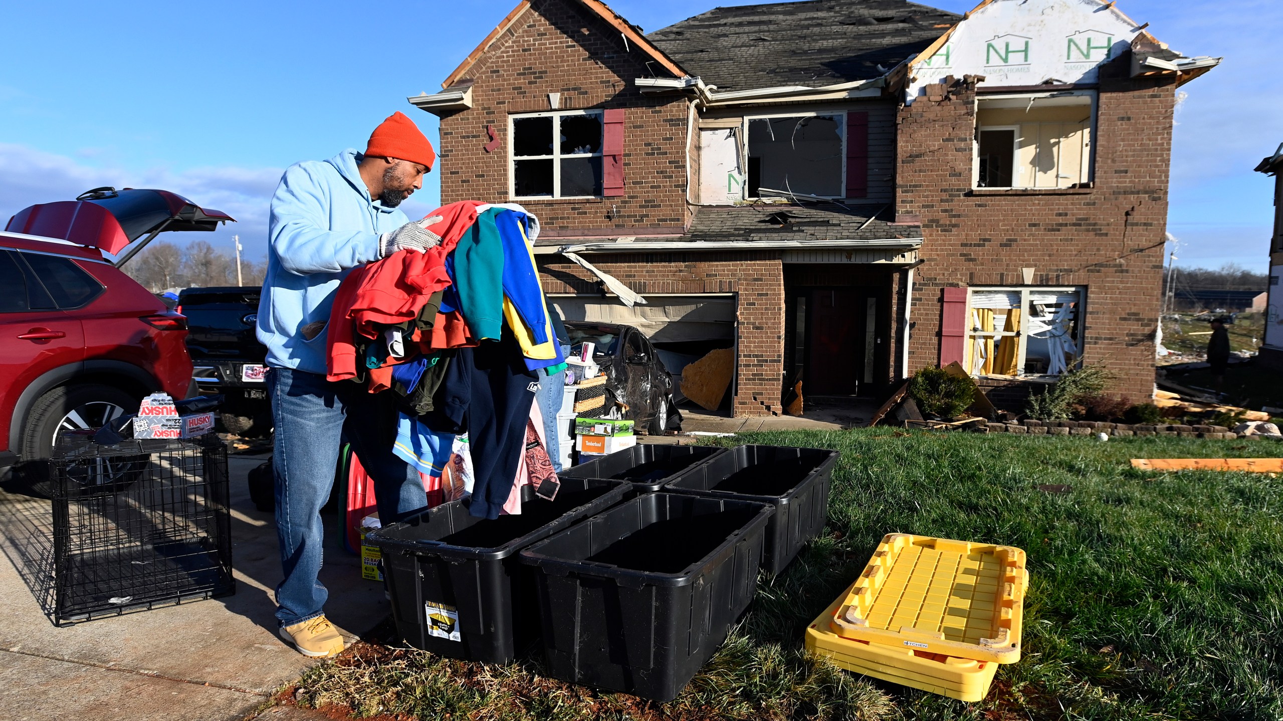 David Rogers gathers clothes from his damaged home in the West Creek Farms neighborhood on Sunday, Dec. 10, 2023, Clarksville, Tenn. Central Tennessee residents and emergency workers are continuing the cleanup from severe weekend storms. (AP Photo/Mark Zaleski)