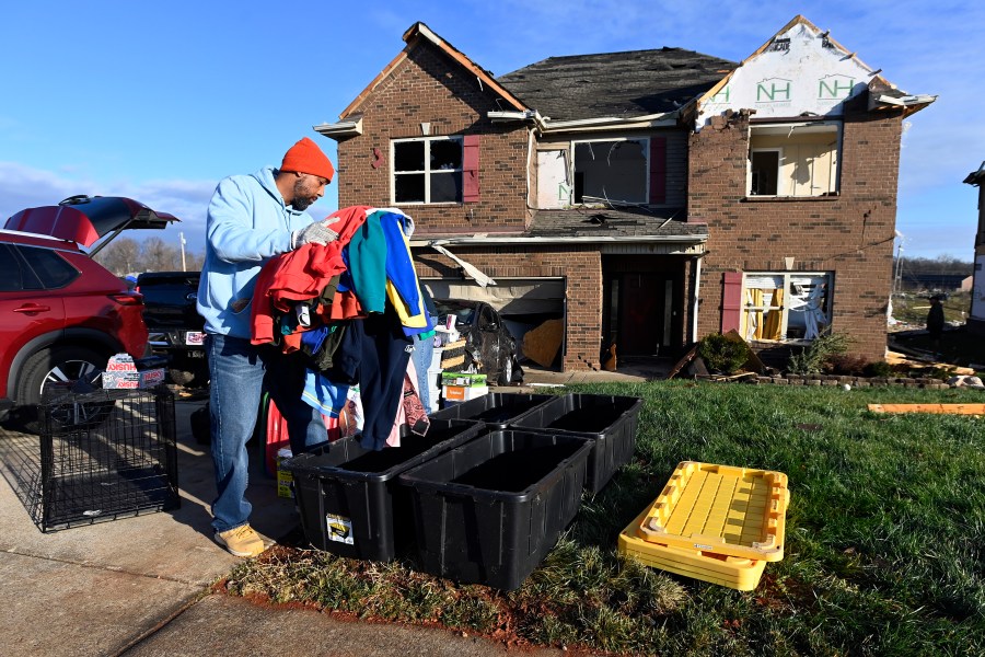 David Rogers gathers clothes from his damaged home in the West Creek Farms neighborhood on Sunday, Dec. 10, 2023, Clarksville, Tenn. Central Tennessee residents and emergency workers are continuing the cleanup from severe weekend storms. (AP Photo/Mark Zaleski)