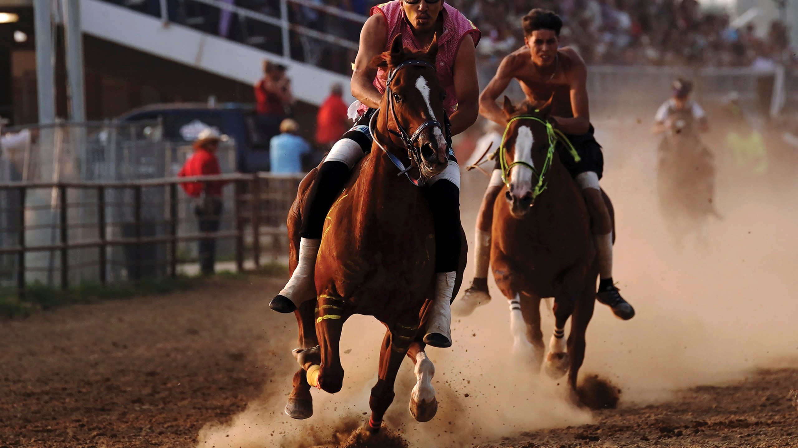 S/M Express' Desmond Archilta, right, competes during the second heat of the World Championship Indian Relay Race during the Sheridan WYO Rodeo, Friday, July 14, 2023, in Sheridan, Wy. Born out of necessity and in mastering skills that came as horses transformed hunting, travel and warfare, rodeo has remained popular in Native American communities. Grandstands often play host to mini family reunions while Native cowboys and cowgirls show off their skills roping, riding and wrestling livestock. (Matt Gaston/Sheridan Press via AP)