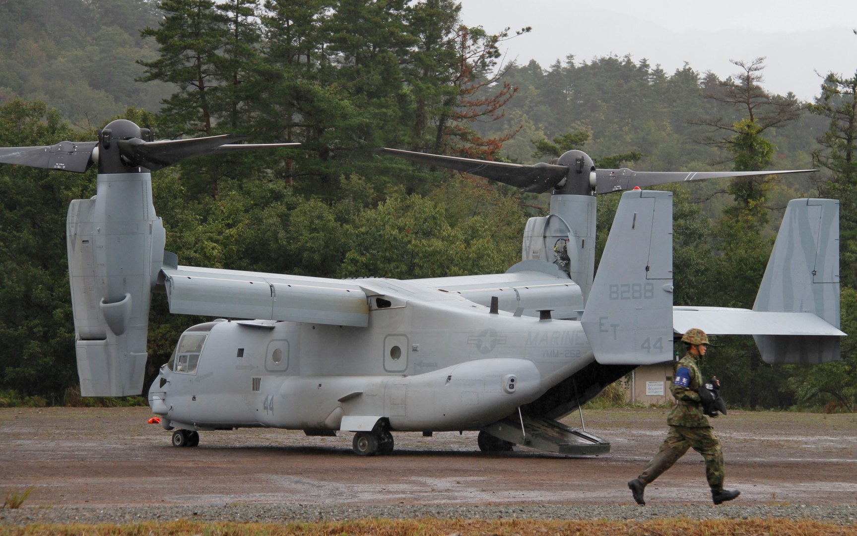 In this Wednesday, Oct. 16, 2013 photo, a Japanese Self-Defense Force photographer runs by a U.S. Marine Corps MV-22 Osprey aircraft during the Japan-U.S. bilateral military exercise called "Forrest Light" at Aibano training site in Shiga prefecture, western Japan. U.S. Marine Corps MV-22 Osprey aircrafts participated in a Japan-U.S. bilateral military exercise for the first time in Japan Wednesday, aiming to ease long standing anger over the heavy presence of American troops on Okinawa. (AP Photo/Koji Ueda)