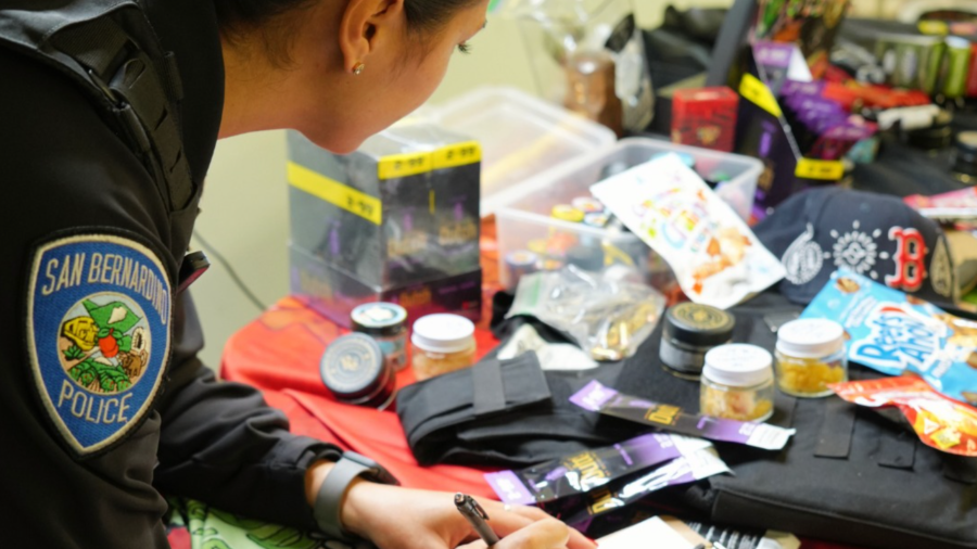 An officer takes inventory after a "sesh" bust in San Bernardino on Dec. 21, 2023. 