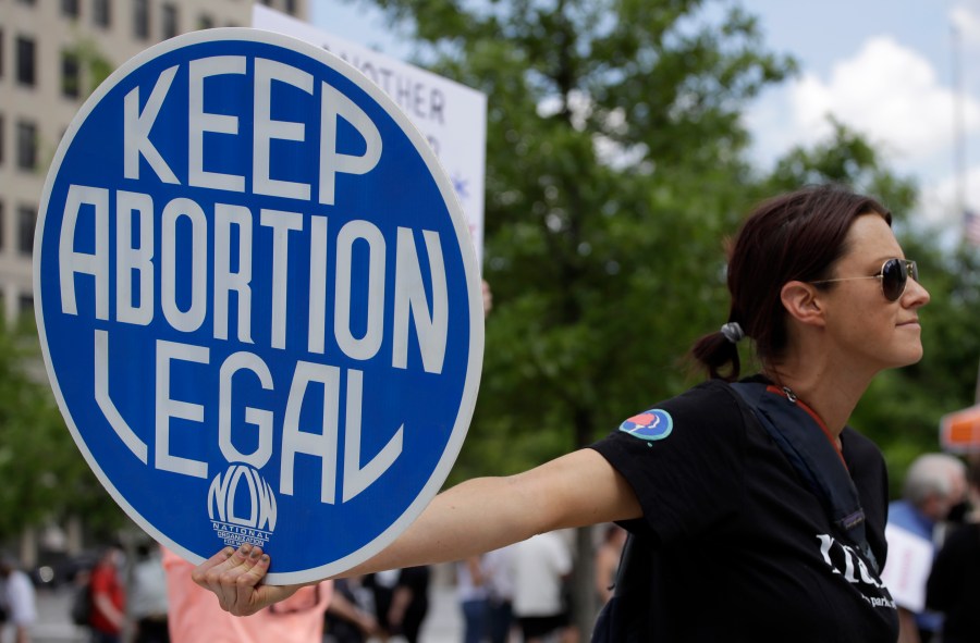 FILE - An abortion-rights demonstrator holds a sign during a rally, May 14, 2022, in Chattanooga, Tenn. On Monday, Jan. 8, 2024, more women joined a Tennessee lawsuit challenging the state's broad abortion ban that went into effect shortly after the U.S. Supreme Court overturned Roe v. Wade in 2022. (AP Photo/Ben Margot, File)