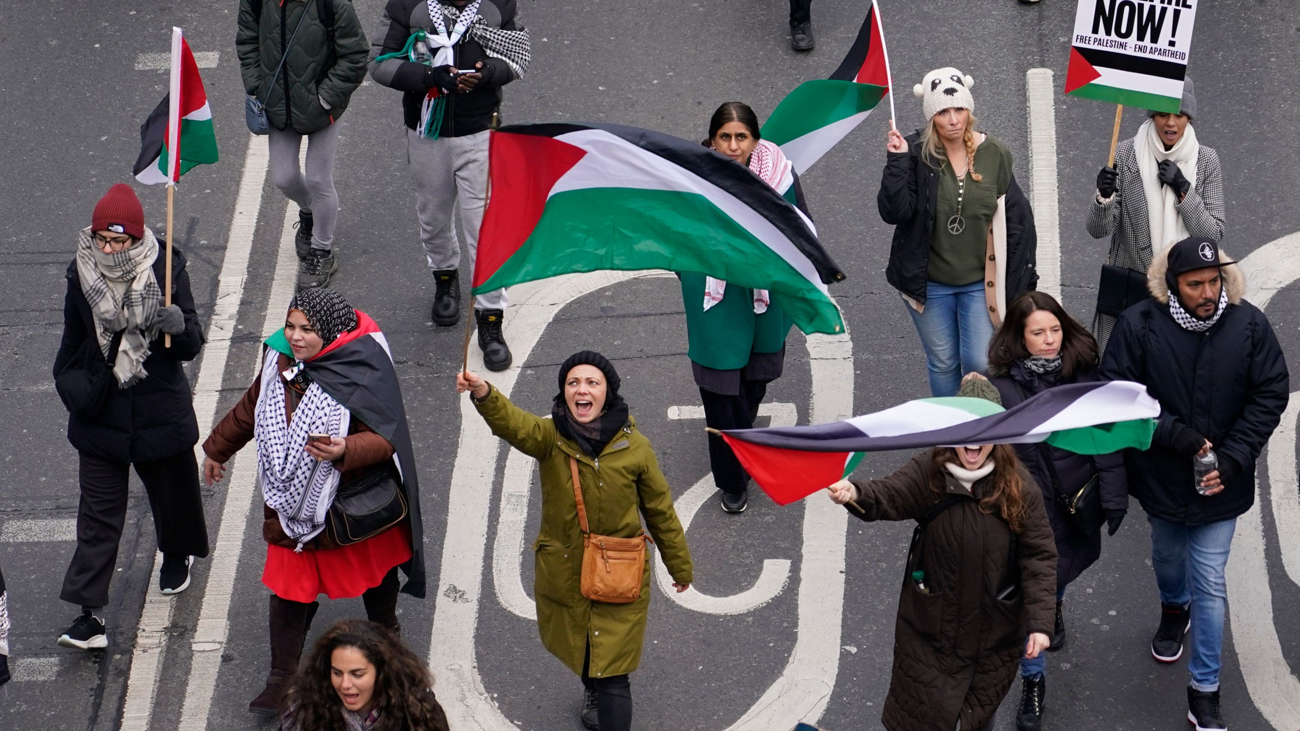 Protesters hold up banners, flags and placards as they walk along the embankment by the River Thames during a demonstration in support of Palestinian people in Gaza, in London, Saturday, Jan. 13, 2024.(AP Photo/Alberto Pezzali)