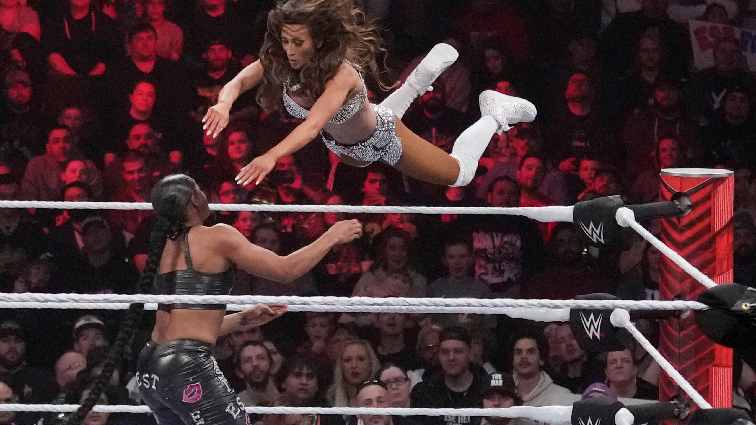 Wrestler Carmella leaps at Bianca Belair, during the WWE Monday Night RAW event, March 6, 2023, in Boston. WWE's weekly television show "Raw" will move to Netflix next year as part of a major streaming deal. (AP Photo/Charles Krupa, File)