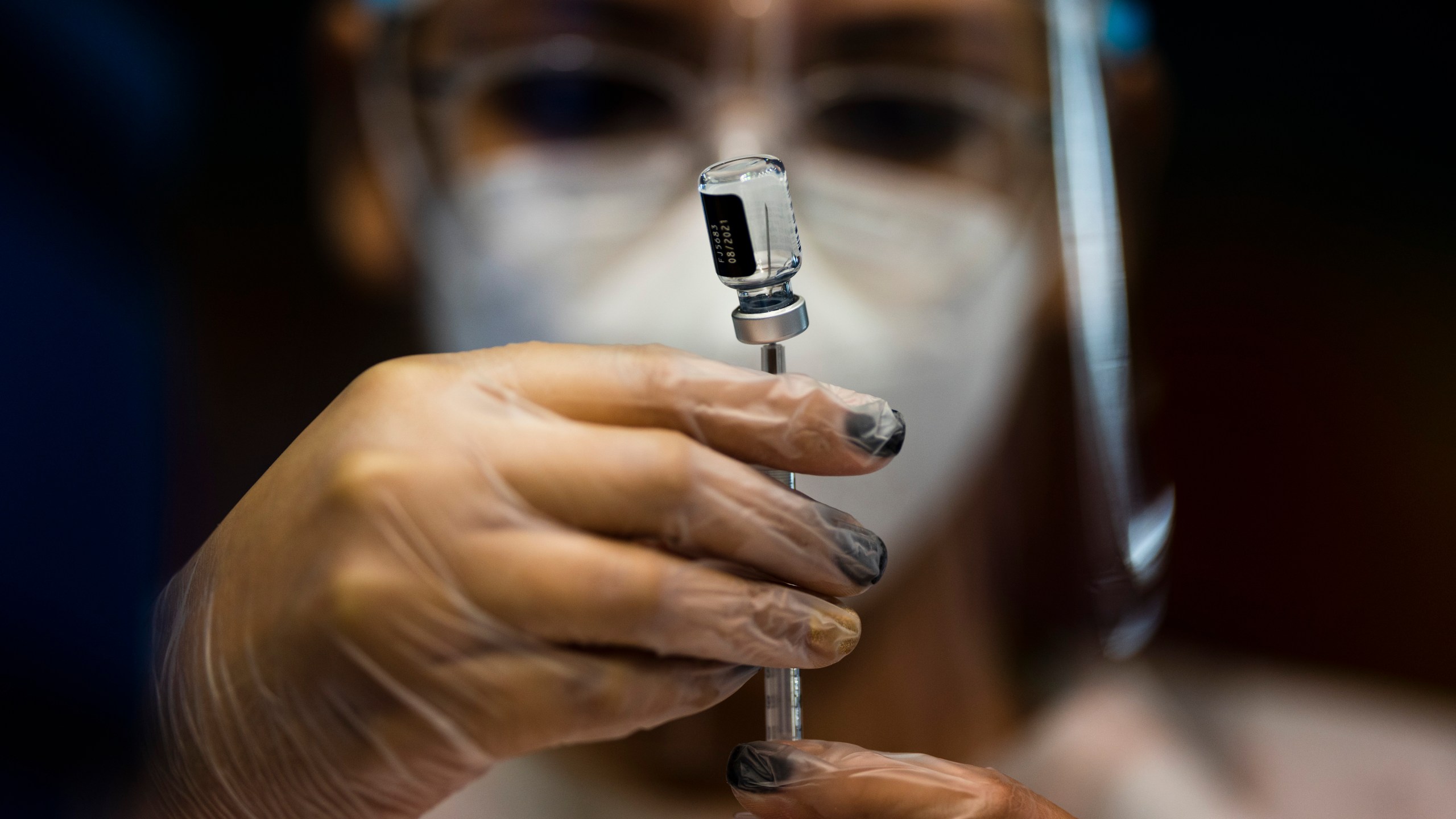 FILE - A nurse prepares a dose of the Pfizer COVID-19 vaccine at the Tomas Dones Coliseum, in Fajardo, Puerto Rico, Jan. 8, 2022. A debate over public health and personal rights intensified on Wednesday, Feb. 14, 2024, as Puerto Rican legislators clashed with medical experts on the use of masks and vaccines. (AP Photo/Carlos Giusti, File)