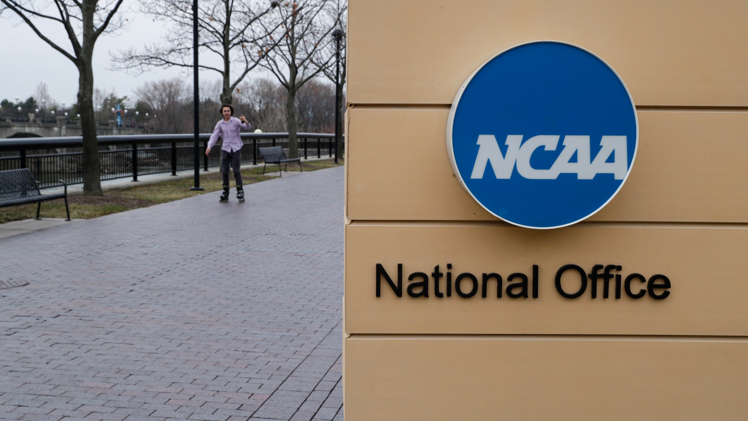 FILE - NCAA signage outside the headquarters in Indianapolis, Thursday, March 12, 2020. Forced into yet another courtroom to defend its amateur model of athletics, the NCAA argued that shelving its rules against name, image and likeness compensation being offered to recruits would make an already difficult situation across the country even more chaotic. (AP Photo/Michael Conroy, File)