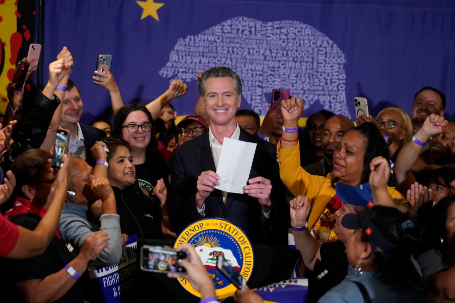 FILE - California Gov. Gavin Newsom signs the fast food bill surrounded by fast food workers at the SEIU Local 721 in Los Angeles, on Thursday, Sept. 28, 2023. Republican leaders in California are calling for an investigation into why a new state law requiring a $20 minimum wage for fast food workers includes an exemption for restaurants like Panera Bread. (AP Photo/Damian Dovarganes, File)