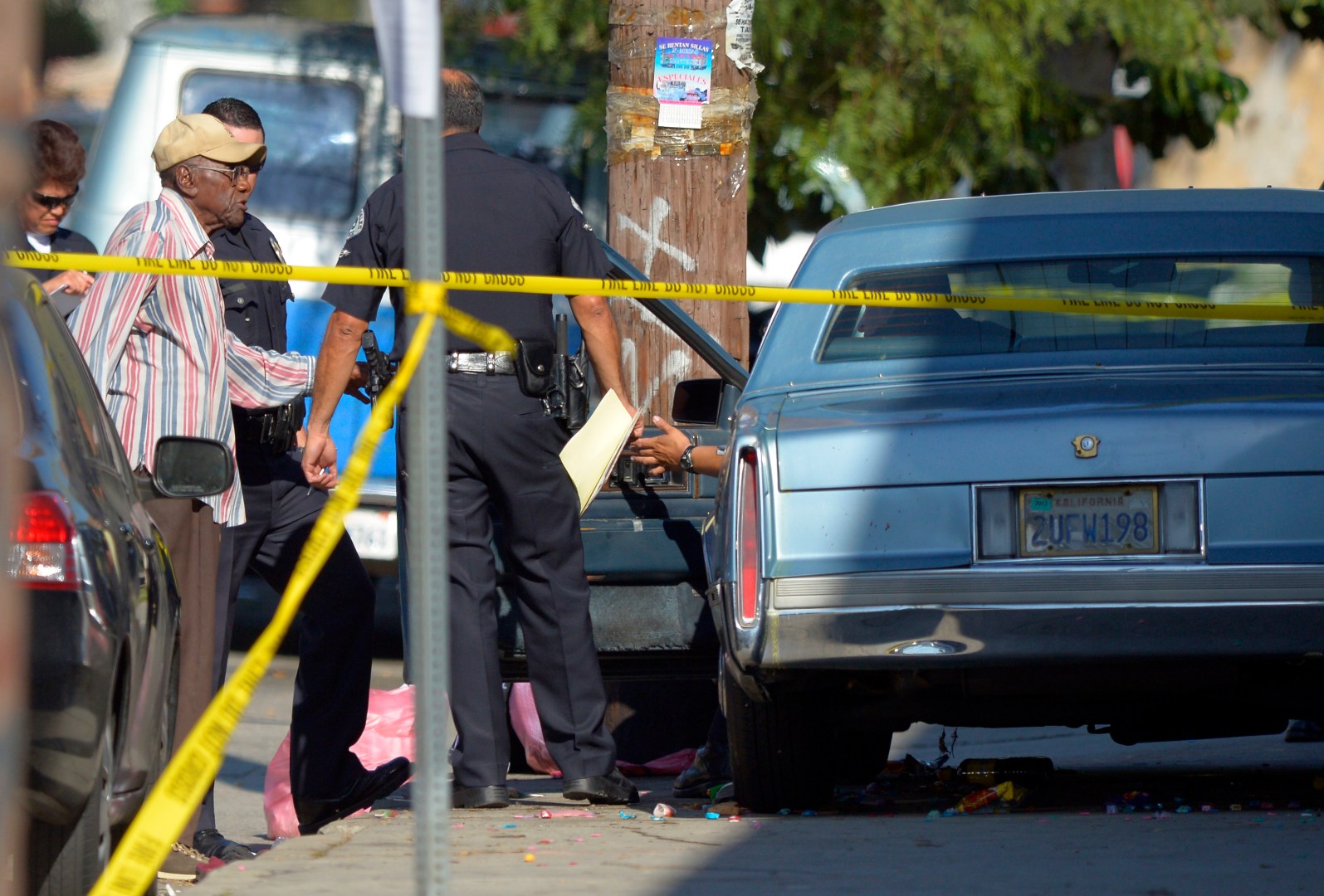 Preston Carter, left, 100, talks with police officers after police say his car went onto a sidewalk and plowed into a group of parents and children outside a South Los Angeles elementary school, Wednesday, Aug. 29, 2012, in Los Angeles. Nine children and two adults were injured in the wreck. (AP Photo/Mark J. Terrill)