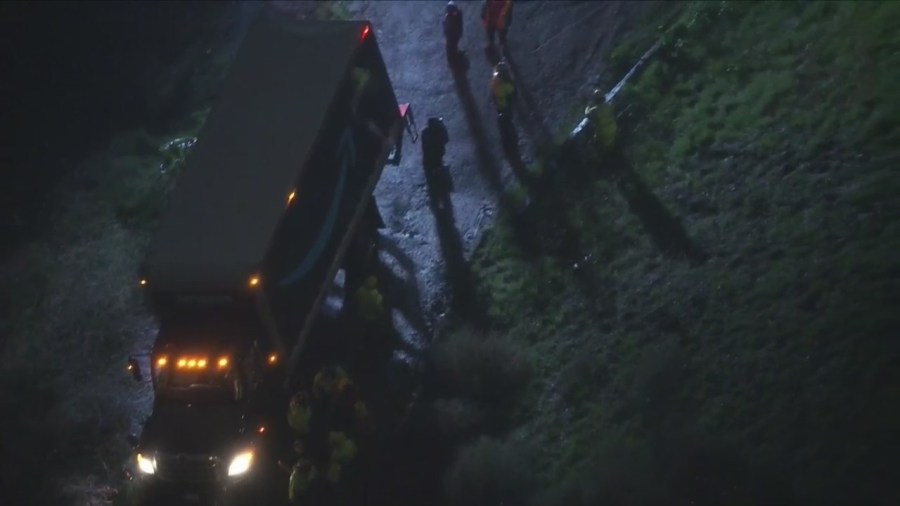 Amazon delivery truck stuck on hillside, threatening home below