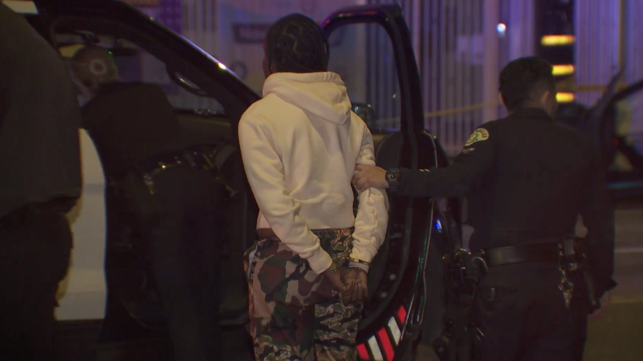 A woman is taken away in handcuffs following a fatal crash in South Los Angeles on Feb. 12, 2024.